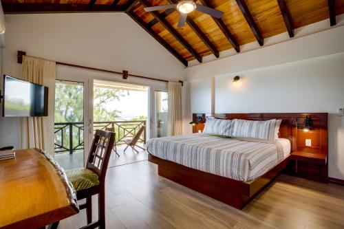 a bedroom with a bed and a desk and a television at Marsh Madness in Maya Beach