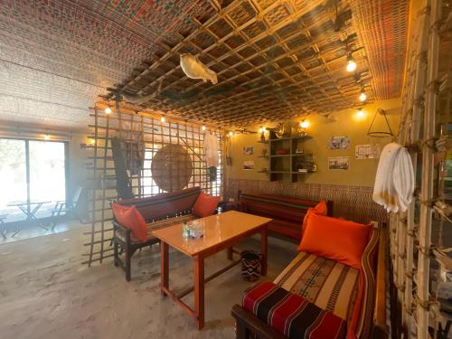 a living room with two benches and a table at Al Bait resort with private swimming pools -HRS stables in Al Ḩamrānīyah