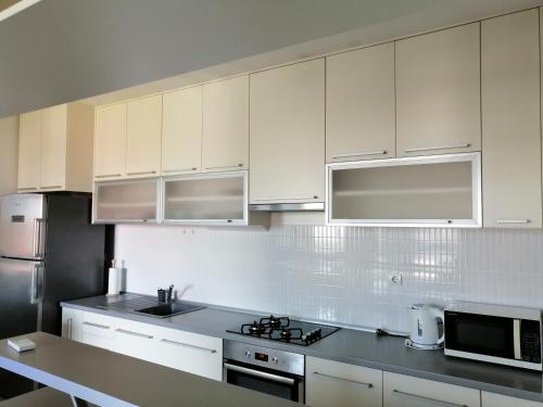 cocina con armarios blancos y fogones en Apartment Bencic, en Umag