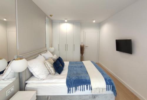 um quarto com uma cama e uma televisão na parede em Marina View 15 & SPA em Dziwnów
