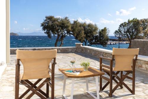 two chairs and a table with a glass of wine at Vivianna's View in Azolimnos