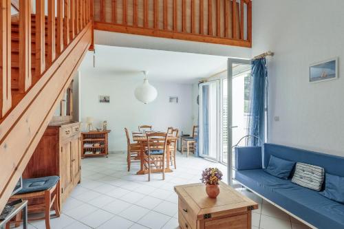 a living room with a blue couch and a table at Maison Avocette - Welkeys in Saint-Trojan-les-Bains