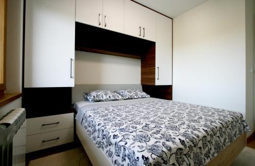 a bedroom with a bed and white cabinets at Apartment Lara in Belgrade