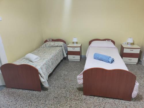 een kamer met twee bedden en twee nachtkastjes bij Villa Pasqualina -(Sobrietà e Semplicità) in Portici