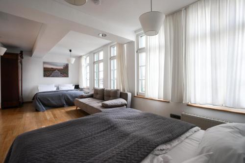 a bedroom with two beds and a couch and windows at LOFT13 Traumhafte Wohnung mit Terrasse für 8 Gäste in Monschau