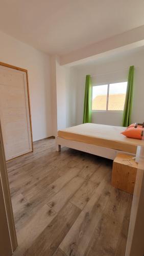 1 dormitorio con cama y ventana en Baia Palmeira Residence, en Palmeira