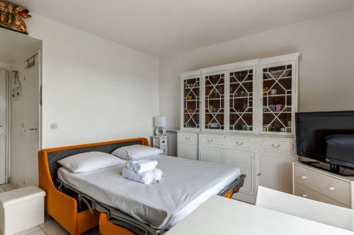 - une petite chambre avec un lit et une télévision dans l'établissement Studio Conac - Welkeys, à Trouville-sur-Mer