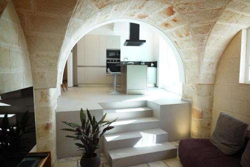 un arco que conduce a una sala de estar con escaleras en Miro Luxury Home, en San Vito dei Normanni