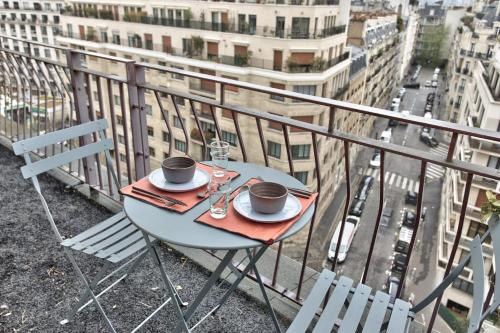 einen Tisch mit zwei Tassen Kaffee auf einem Balkon in der Unterkunft Superb 1 bedroom flat with balcony near the Eiffel Tower - Paris - Welkeys in Paris