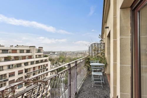 einen Balkon eines Gebäudes mit einem Tisch und Stühlen in der Unterkunft Superb 1 bedroom flat with balcony near the Eiffel Tower - Paris - Welkeys in Paris