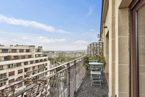 - un balcon d'un immeuble avec une table et des chaises dans l'établissement Appartement Doumer et son balcon - Welkeys, à Paris