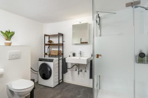 een badkamer met een wasmachine en een wastafel bij KAKADU - Zentral - Workplace - Top Ausstattung in Frankenberg
