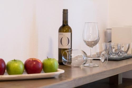 a bottle of wine and two apples on a table at Vivianna's View in Azolimnos