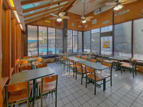a dining room with tables and chairs and windows at Sidney James Mountain Lodge in Gatlinburg