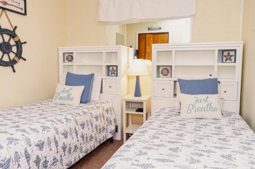 Duas camas num quarto com roupa de cama azul e branca em Myrtle Beach Resort A145 em Myrtle Beach