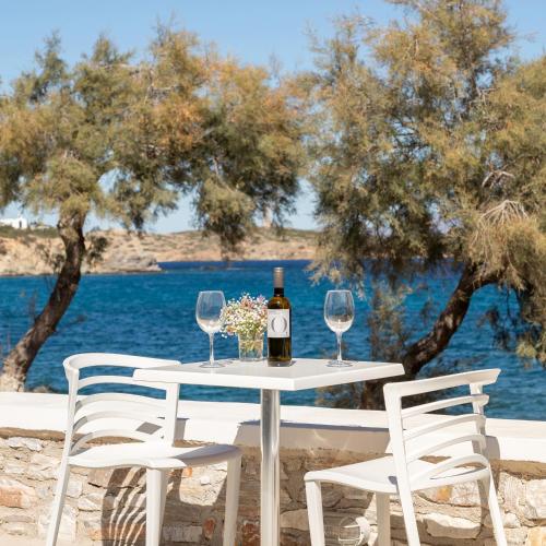 a table with a bottle of wine and two chairs at Vivianna's View in Azolimnos