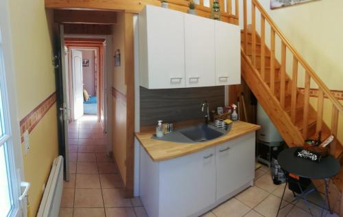 une cuisine avec un évier et un escalier dans l'établissement Charmante petite dépendance, à Soullans
