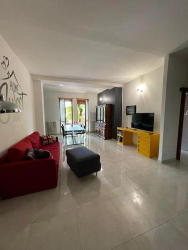 een woonkamer met een rode bank en een tafel bij Terrace house appartamento mq 80 adiacente ospedale e clinica in Piacenza