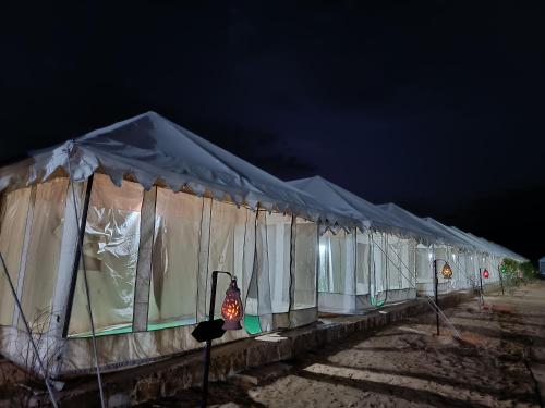 a row of tents lined up at night at Nagina Desert Camp in Sām