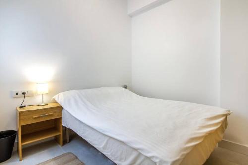 a bedroom with a bed and a nightstand with a white bedspread at SEA VIEW, walking distance! Refurbished 2 bed, modern. 20 min. from Alicante Airport in Santa Pola