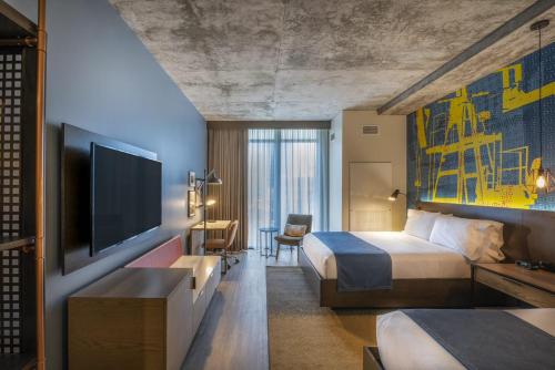 a hotel room with a bed and a flat screen tv at Hotel Indigo Tulsa DWTN/Entertainment Area in Tulsa