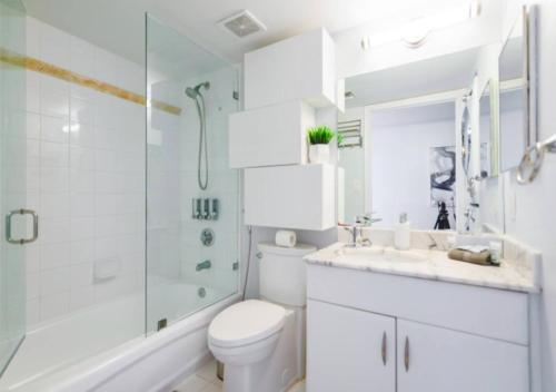 a white bathroom with a toilet and a shower at Exquisite Ocean View 3 BR Apartment in Miami