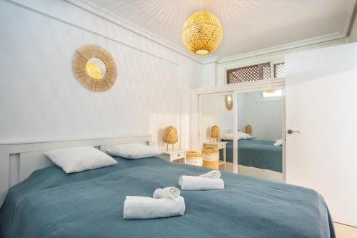 a bedroom with a blue bed with towels on it at Flamingo Apartment on the south near the beach in Palm-mar
