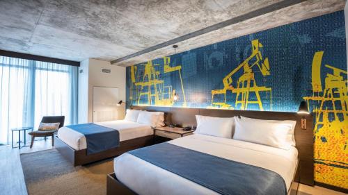 a hotel room with two beds and a painting on the wall at Hotel Indigo Tulsa DWTN/Entertainment Area in Tulsa