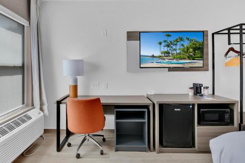 a room with a desk and a television on a wall at Comfort Inn in South Padre Island