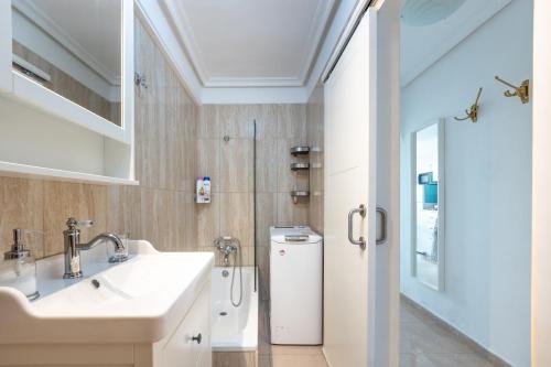 a bathroom with a sink and a refrigerator at Flamingo Apartment on the south near the beach in Palm-mar