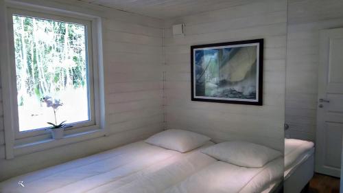 a small room with a bed and a window at Strandstugan, Solviken in Rockneby