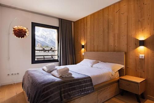 1 dormitorio con 1 cama con toallas en Modern 2BR 5* pool gym spa garage Mont-Blanc view, en Chamonix-Mont-Blanc