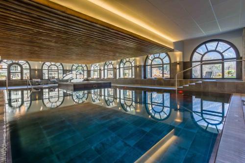 - une piscine dans un bâtiment avec fenêtres dans l'établissement Modern 2BR 5* pool gym spa garage Mont-Blanc view, à Chamonix-Mont-Blanc