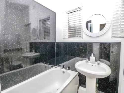 y baño con lavamanos, bañera y lavamanos. en Homely 4 Bedroom large house inc FREE Parking - Great Location - Fast WiFi - Smart TV - sleeps up to 7! Close to Bournemouth & Poole Town Centre & Sandbanks en Bournemouth