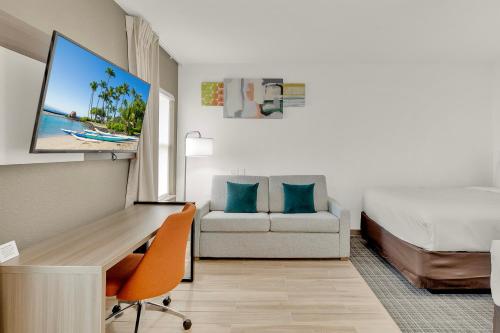 a hotel room with a desk and a bed and a couch at Comfort Inn in South Padre Island