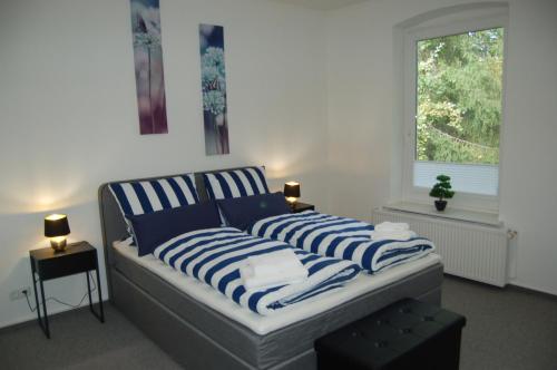 a bedroom with a bed with blue and white striped pillows at Haus Regine in Rendsburg
