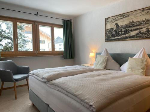 a bedroom with a large bed and a chair at Apartmenthaus am Tegernsee - Studios mit Küchenzeile und mit Bus erreichbar in Bad Wiessee