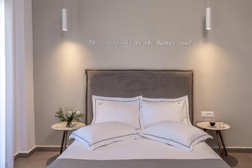 a bedroom with a bed with the words the sea speaks to the human soul at Vivianna's View in Azolimnos