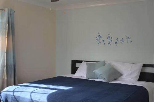 1 dormitorio con 1 cama con sábanas y almohadas azules en the terrace 2 bedroon apartment en Kingston
