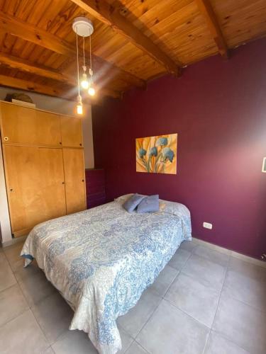 1 dormitorio con cama y pared púrpura en Lo de Lili a pasos del Centro de Tandil en Tandil