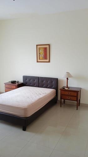 1 dormitorio con 1 cama, 1 mesa y 1 lámpara en Apartamento en Guayaquil, sector Urdesa Central, en Guayaquil