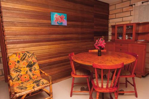 una sala da pranzo con una parete in legno, tavolo e sedie di Pousada Água dos Canyons a Praia Grande