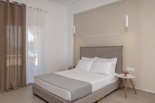 a bedroom with a white bed and a window at Vivianna's View in Azolimnos
