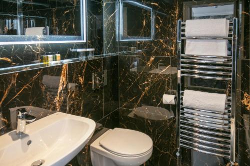 a bathroom with a toilet and a sink at Best Western Hotel 99 in Blackburn