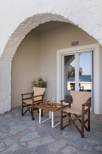 a patio with two chairs and a table in front of the beach at Vivianna's View in Azolimnos