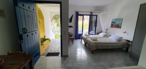 a bedroom with two beds and a room with a mirror at Irini Studios in Georgioupolis