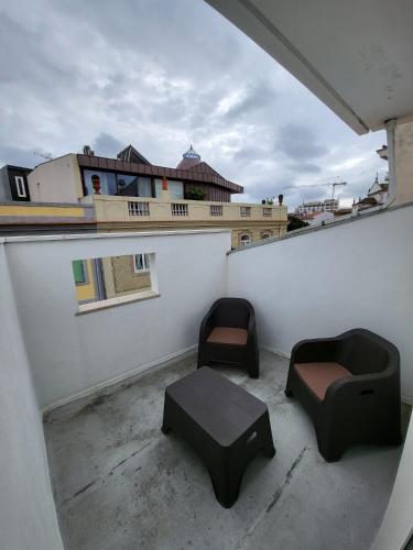 a balcony with two chairs and a table on a building at Galeria Suite Hotel in Aveiro