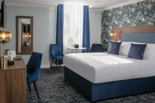 Best Western Hotel 99 في بلاكبيرن: غرفه فندقيه بسرير ومكتب وكراسي