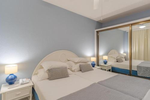 a bedroom with two beds and a mirror at Tranquil Beachside Stay - Atlantic Gardens Beach in Funchal
