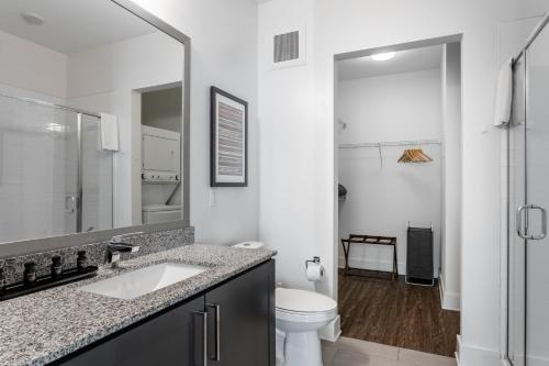 a white bathroom with a sink and a toilet at Mint House Nashville - Music Row in Nashville